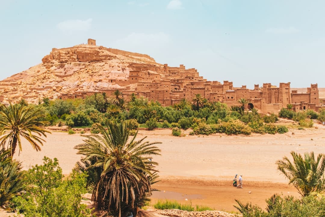 Day trips from Marrakech — Aït Benhaddou UNESCO kasbah at golden hour, clay-brick ksar against the High Atlas
