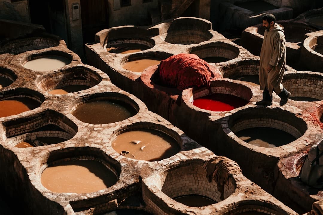 Things to do in Fes — aerial view of the Chouara Tanneries, stone dye pits filled with red and yellow dye in the Fes el-Bali medina